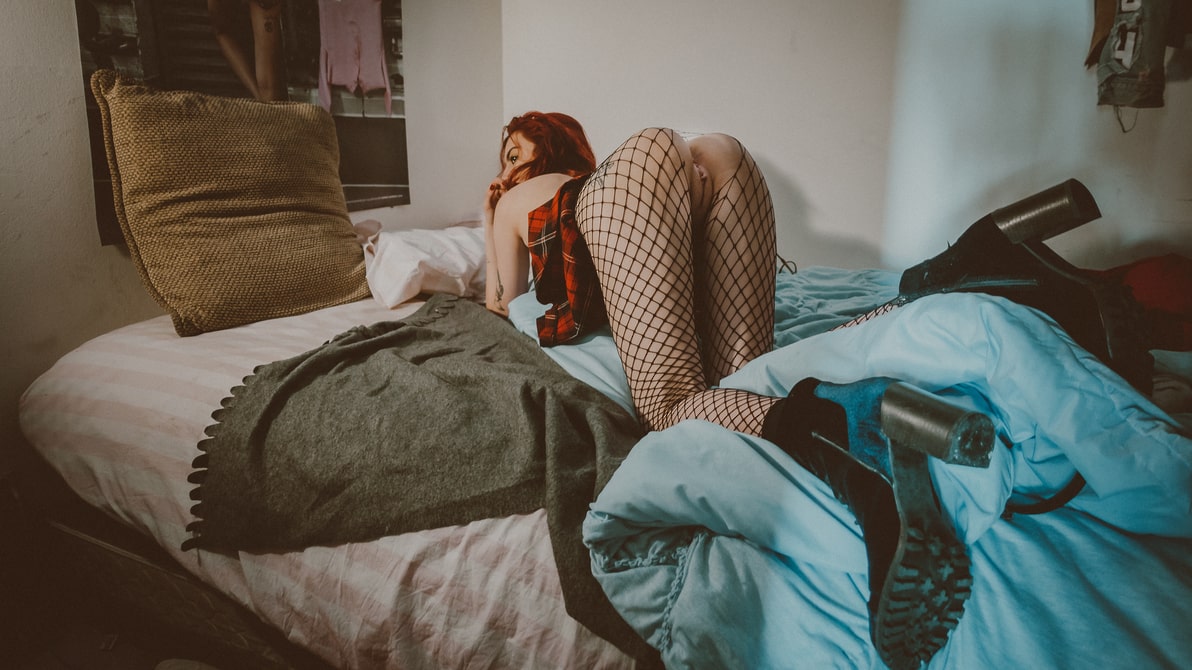 Woman on her bed with her skirt pulled up