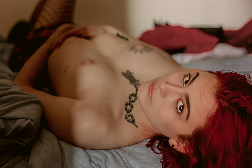 Lark Terry lying naked in her bed exposing her small breasts and bright red hair